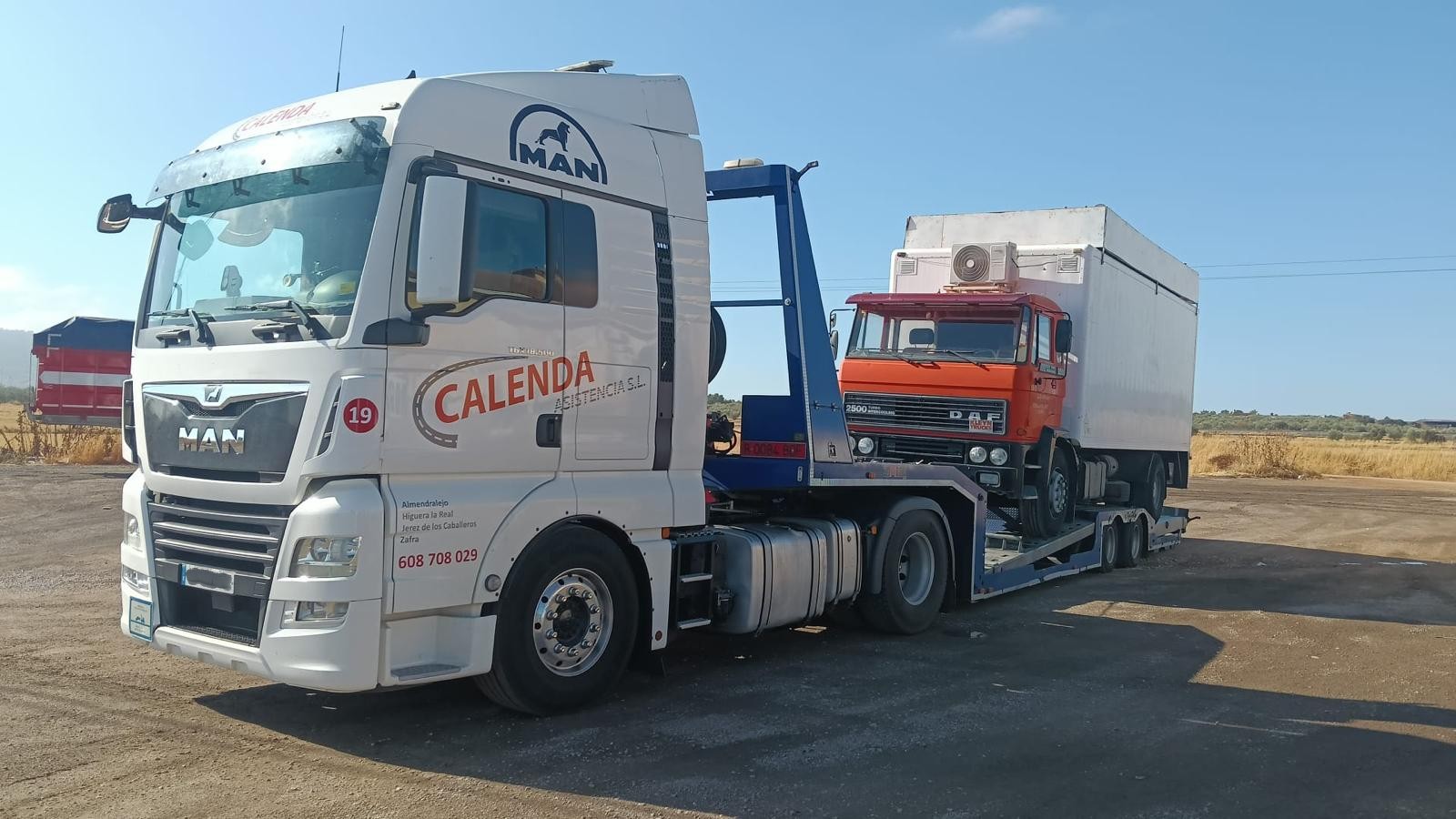 Camión plataforma transportando otro vehículo